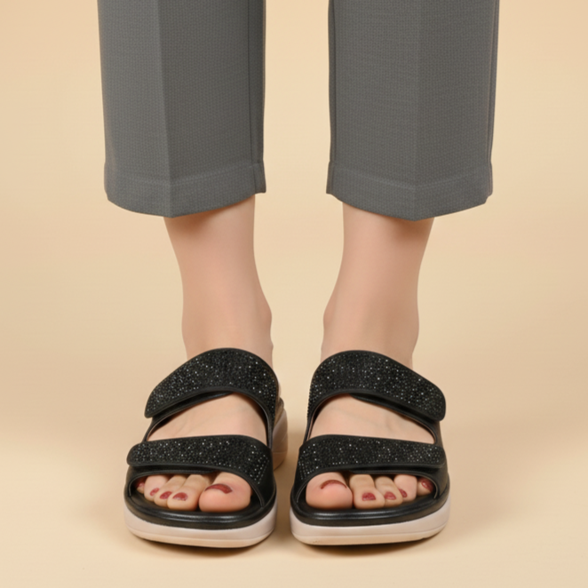 Person wearing black sandals with a beige background