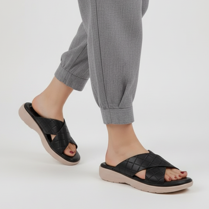 Person wearing black sandals on a white background