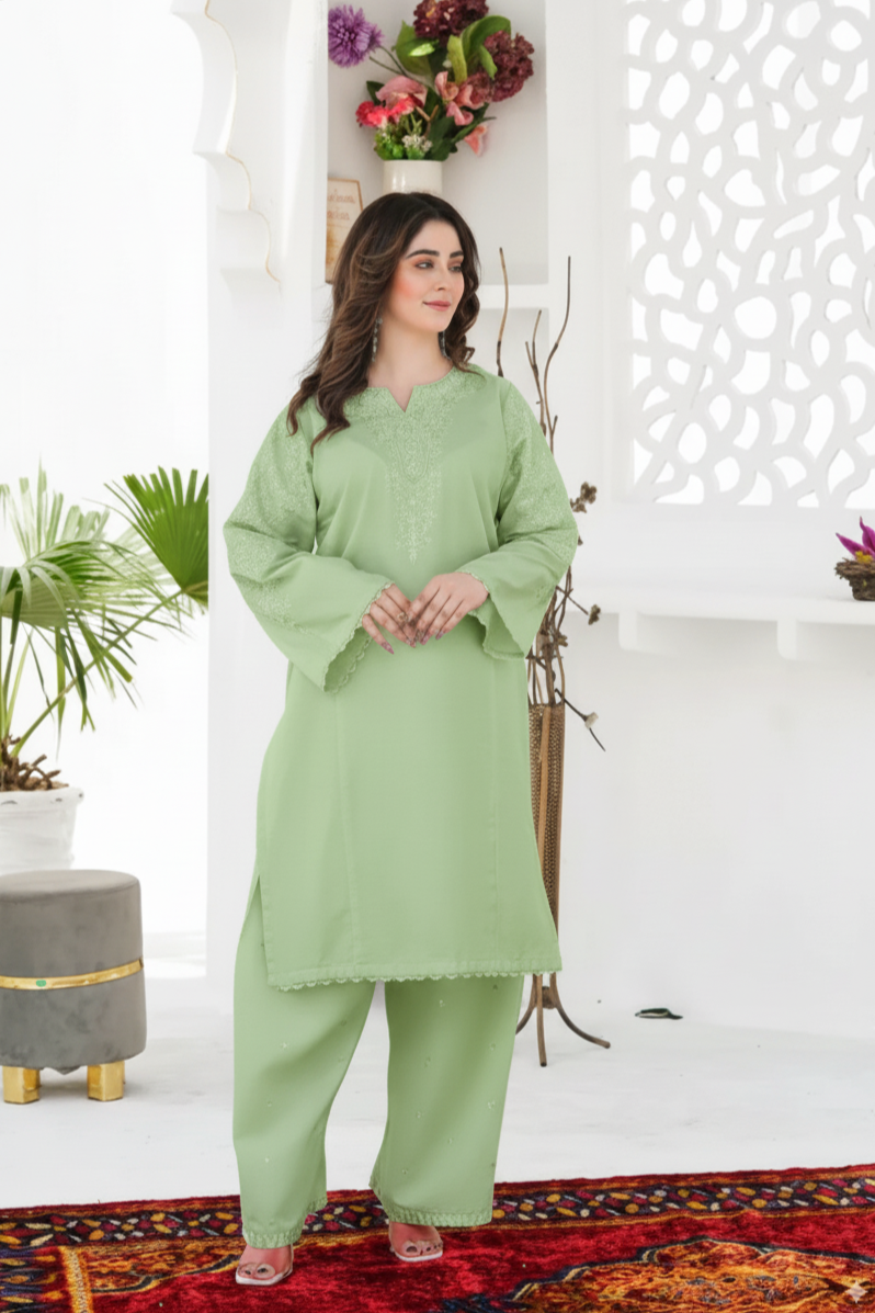 Woman wearing a light green traditional outfit in a decorated room.