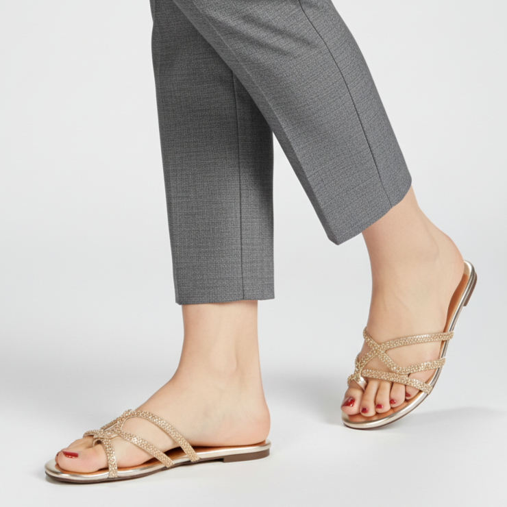 Person wearing gray checkered pants and beige sandals on a white background