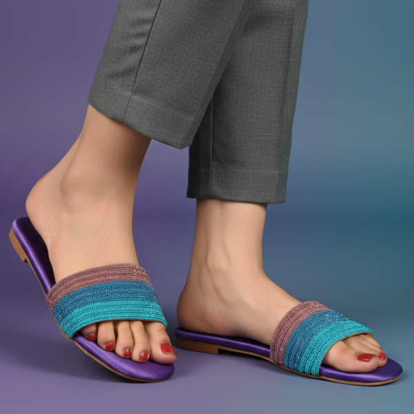 Blue and purple sandals worn with gray pants on a gradient background