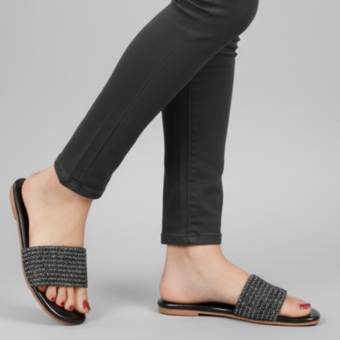 Person wearing black jeans on a gray background