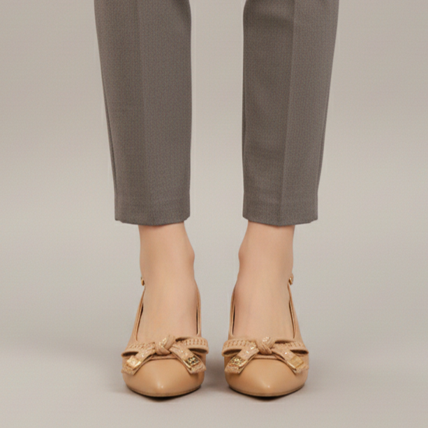 Gray pants worn with beige shoes on a plain background