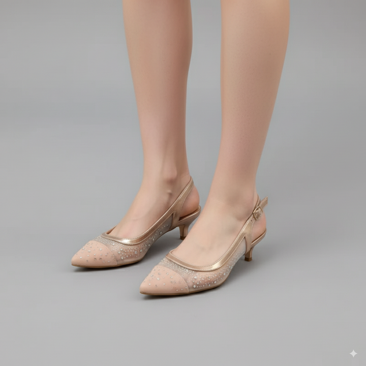 Beige high-heeled shoes worn by a model on a gray background