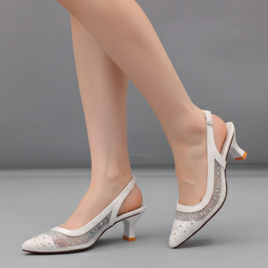 White high-heeled shoes with decorative elements on a gray background