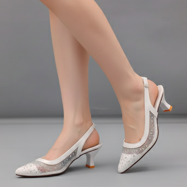 White high-heeled shoes with decorative elements on a gray background