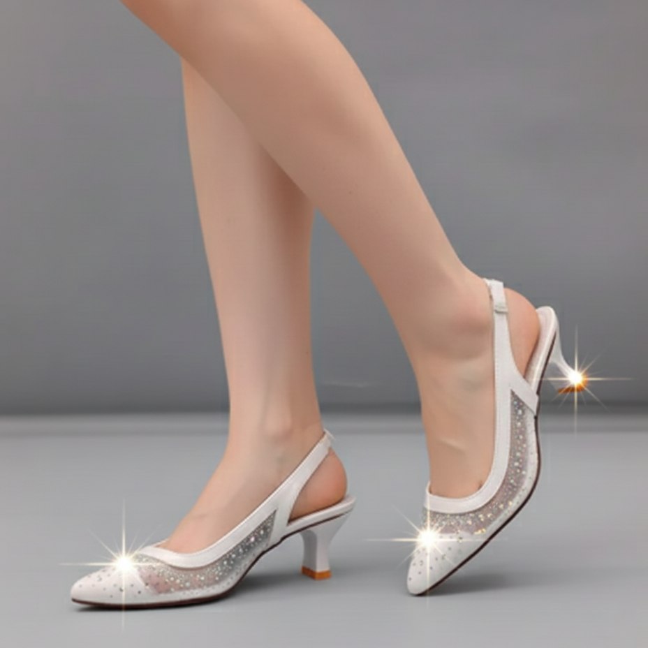 White high-heeled shoes with rhinestone details on a gray background