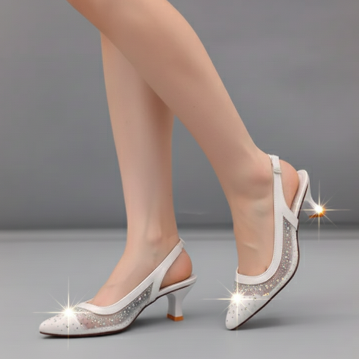 White high-heeled shoes with rhinestone details on a gray background