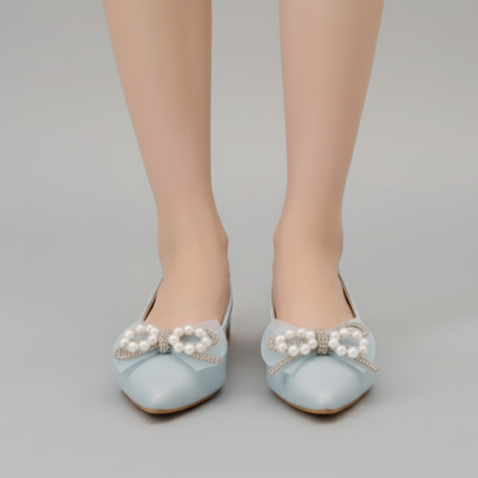 Light blue shoes with pearl embellishments on a neutral background