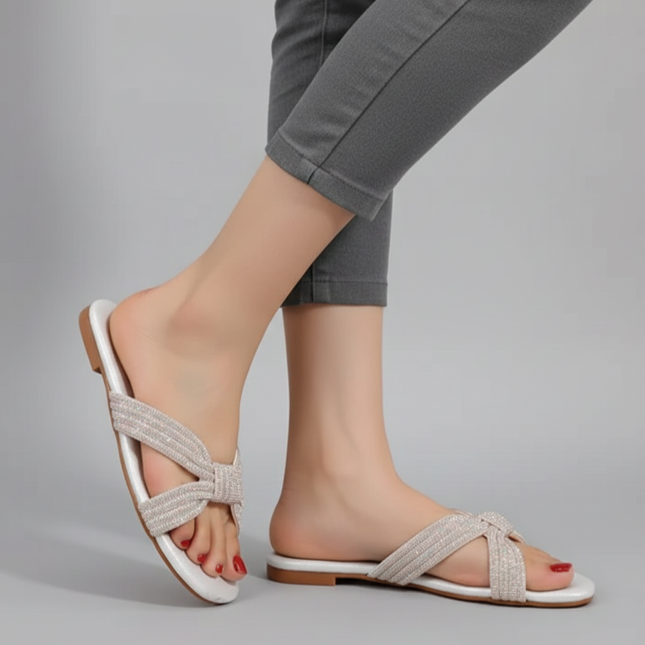 White sandals worn with gray pants on a gray background