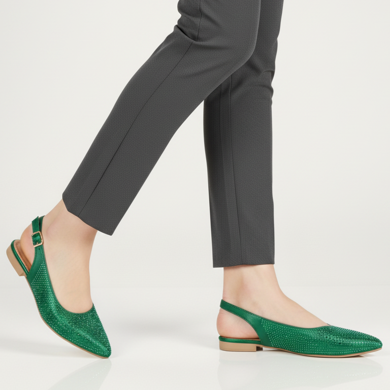 Green pointed-toe flats worn with gray pants on a white background