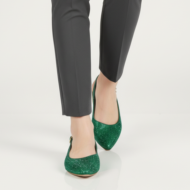 Person wearing black pants and green shoes on a white background