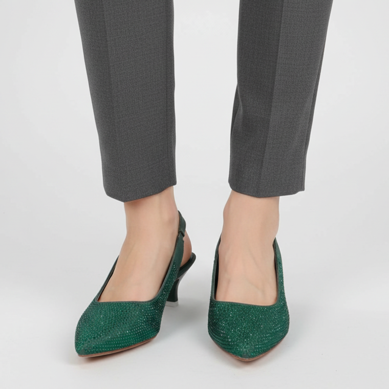 Green high-heeled shoes worn with gray pants on a white background