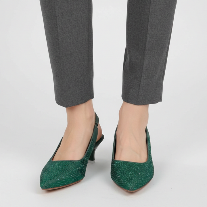 Green high-heeled shoes worn with gray pants on a white background