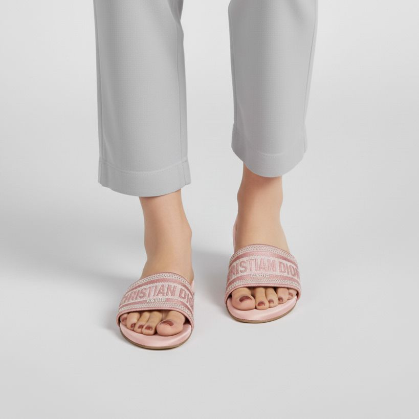 Person wearing pink slides with a brand logo on a light gray background