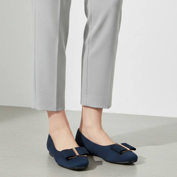 Person wearing navy blue shoes with a white background