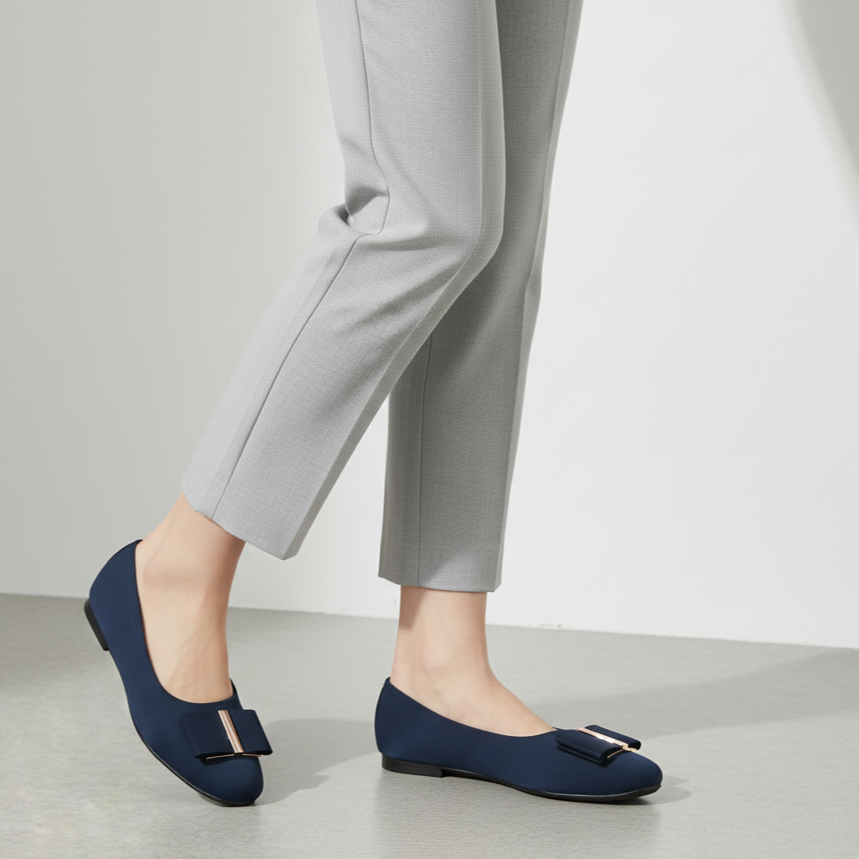 Navy blue flats worn with gray pants on a light background