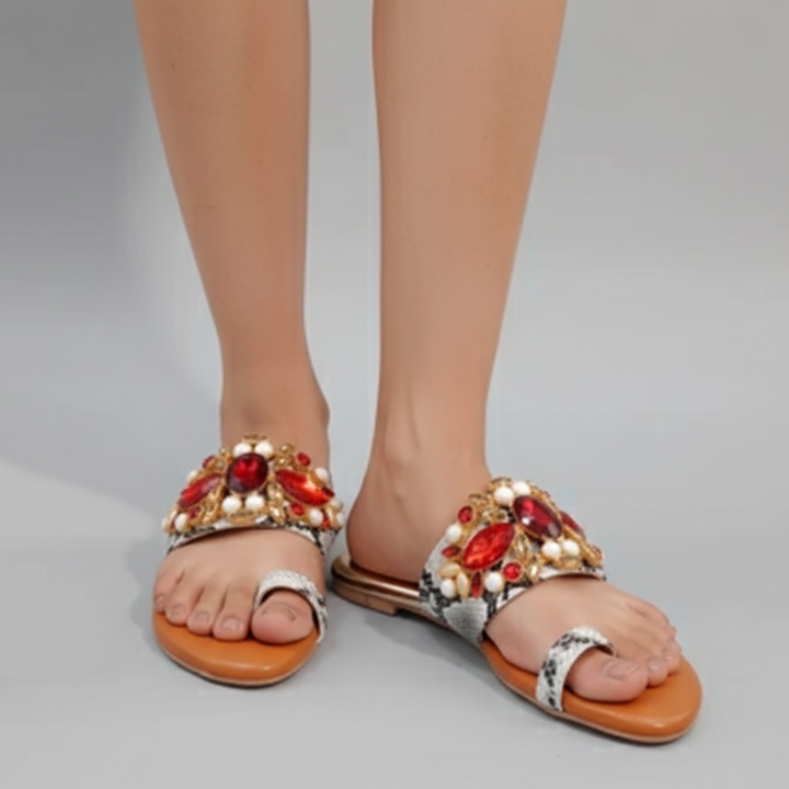 Elegant sandals with gemstone embellishments on a neutral background