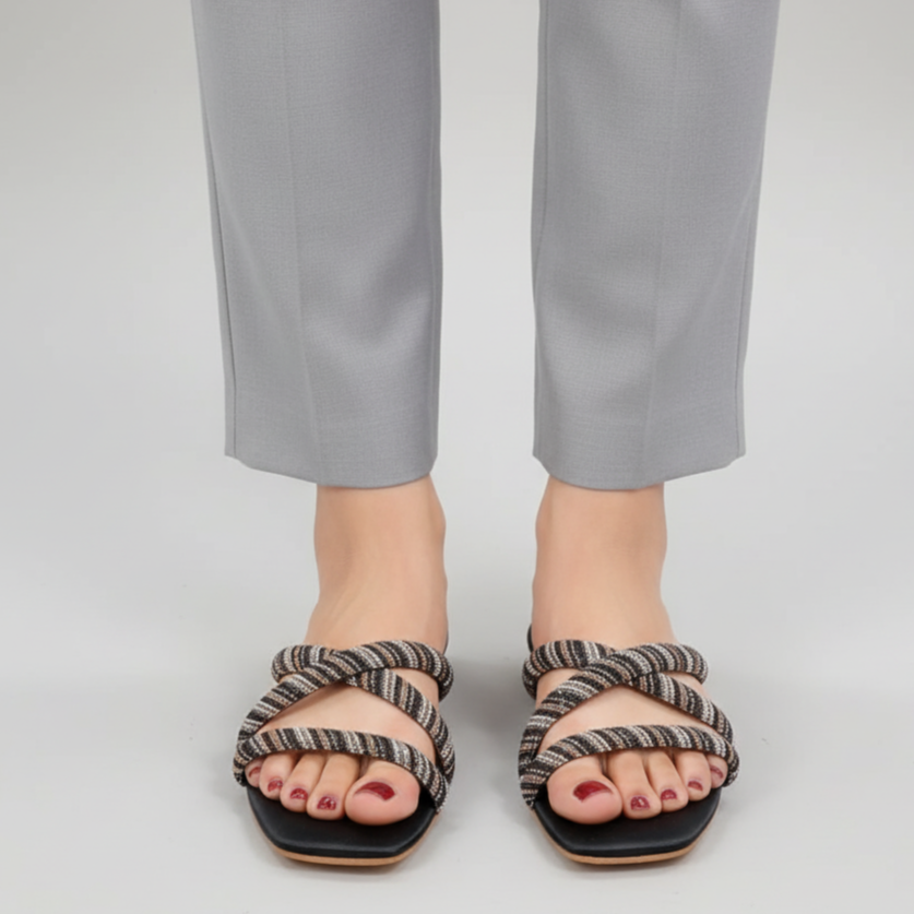 Person wearing striped sandals with a plain background