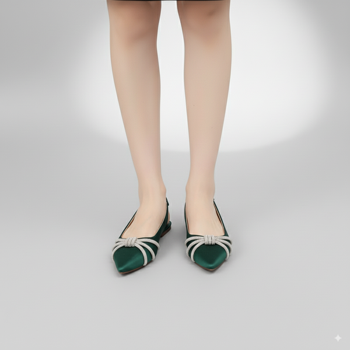 Green flat shoes with white straps worn by a person on a light gray background