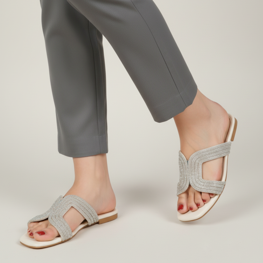 Gray sandals worn with gray pants on a light background