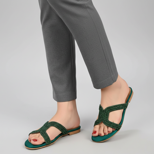 Green sandals worn with gray pants on a light gray background