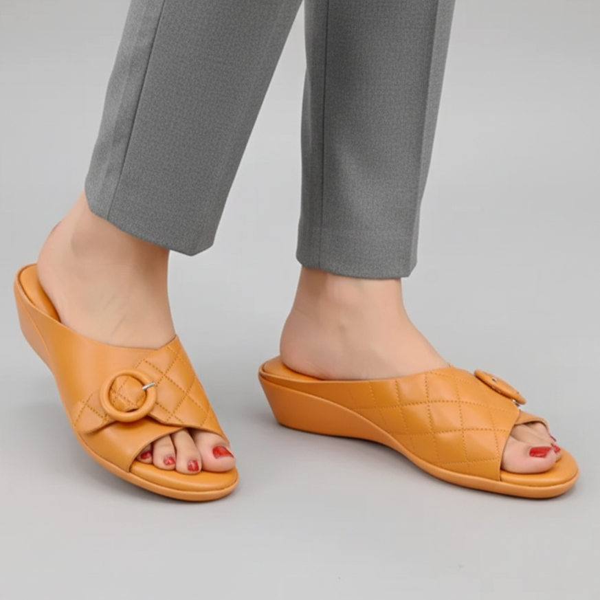 Orange sandals worn with gray pants on a light gray background