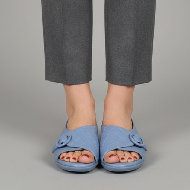 Person wearing gray pants and blue sandals on a gray background