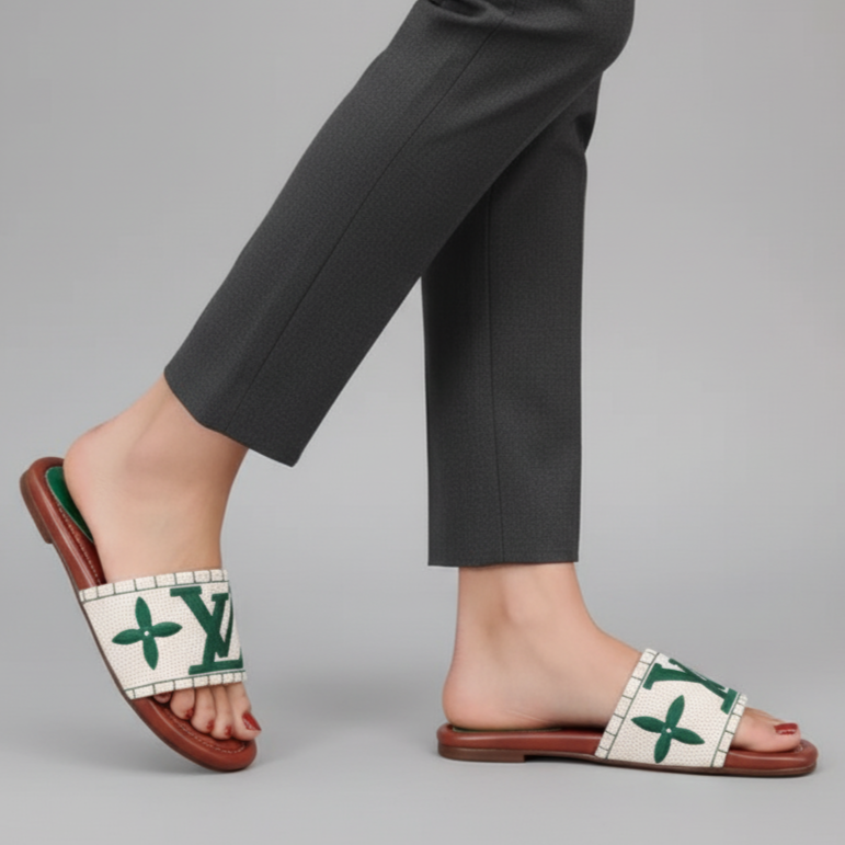 Person wearing green and white sandals with a brand logo on a gray background