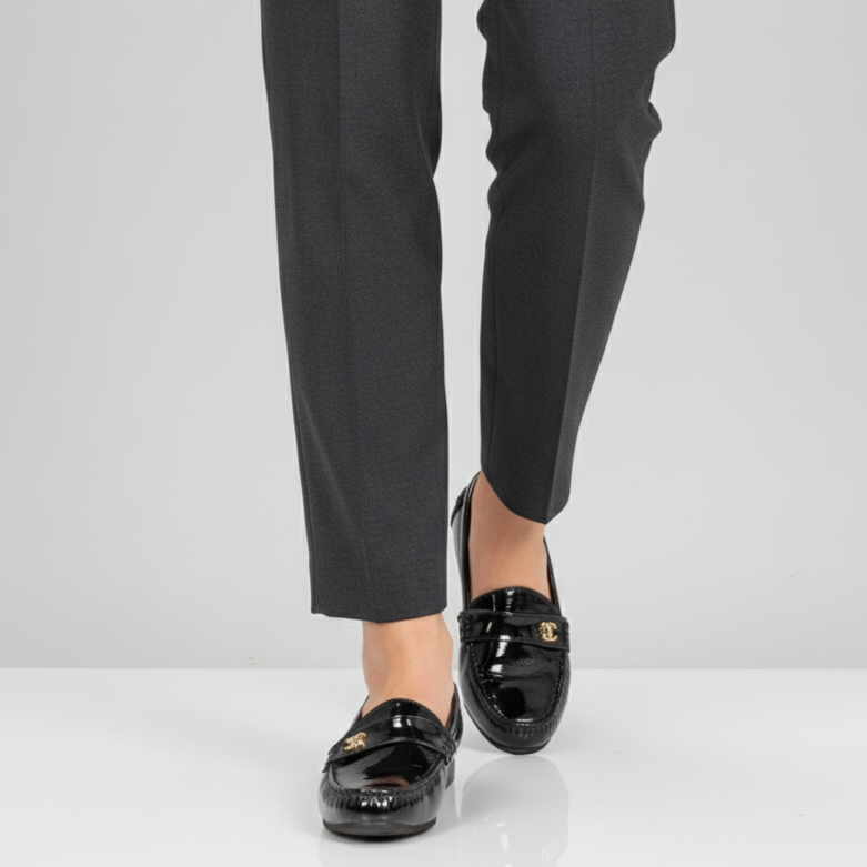 Black dress pants with black loafers on a white background