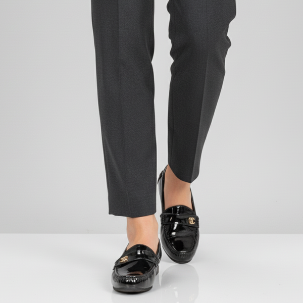 Black dress pants with black loafers on a white background