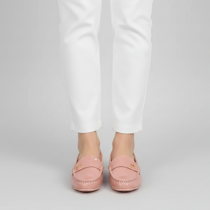 Person wearing pink loafers and white pants on a light gray background