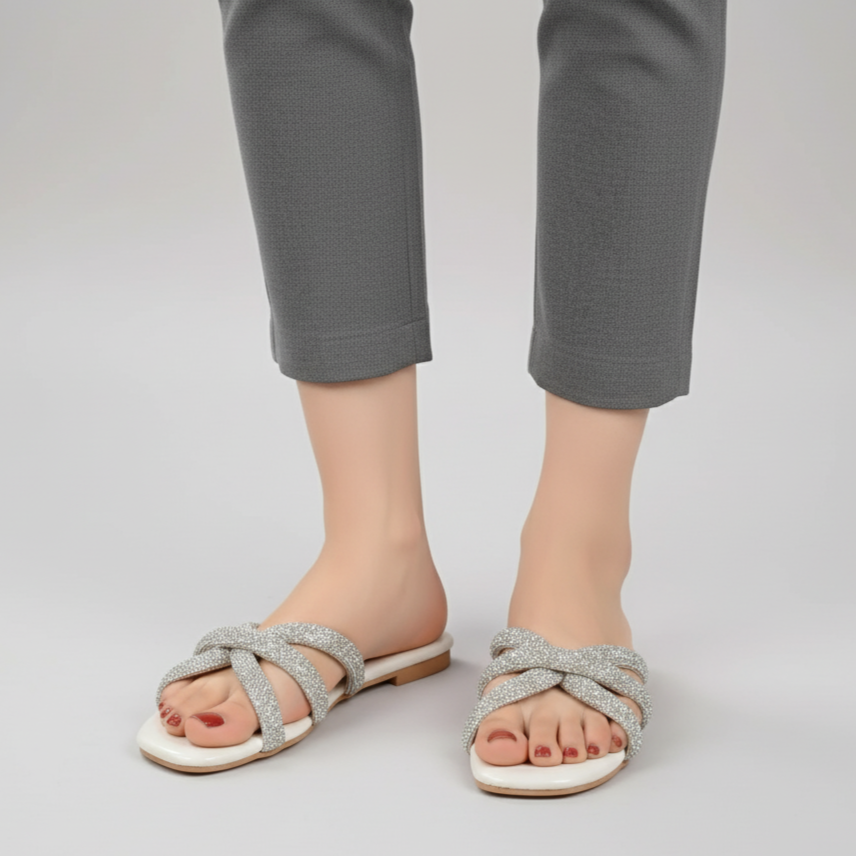 Person wearing silver sandals with a plain background
