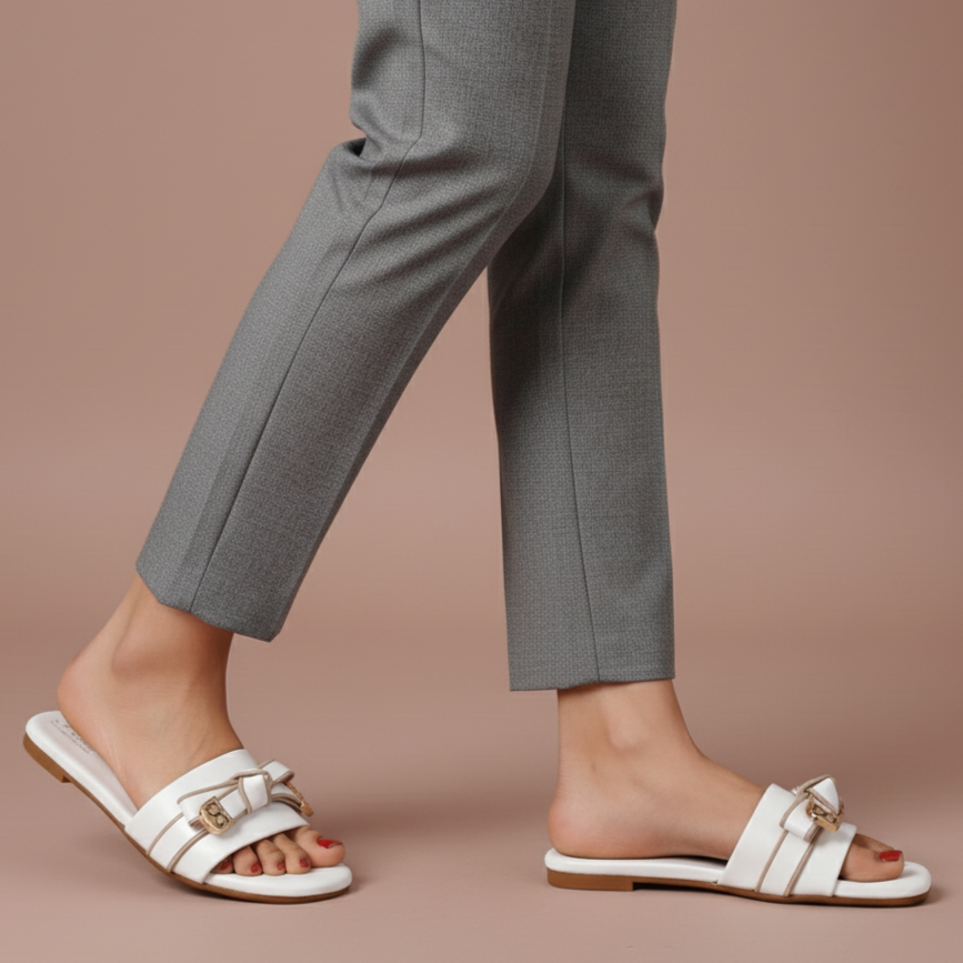 White sandals worn with gray pants on a beige background