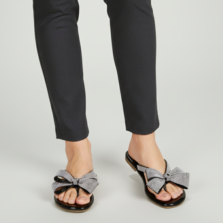 Black pants with checkered bow sandals on a light gray background