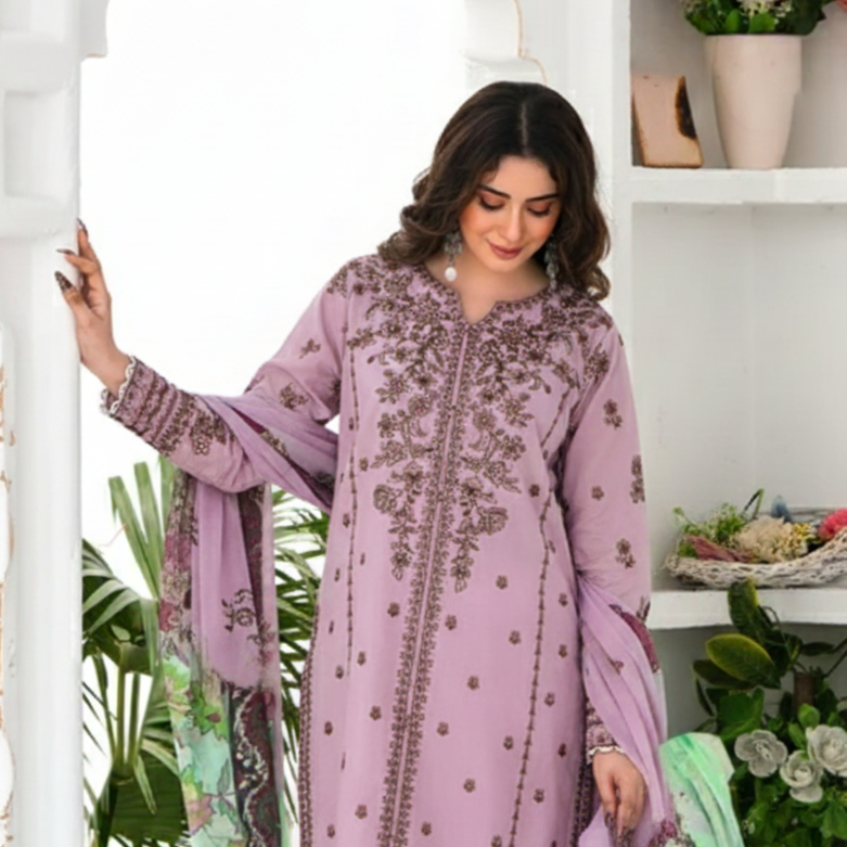 Woman wearing a purple embroidered outfit with a green dupatta in a decorated room.