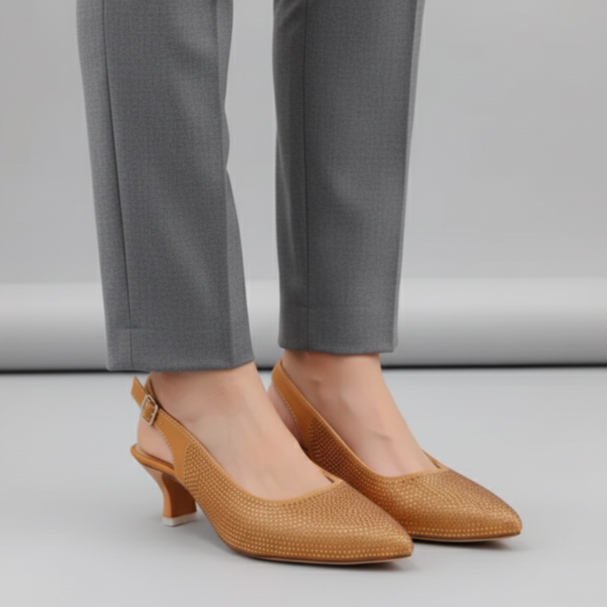 Brown pointed heels worn with gray pants on a light gray background