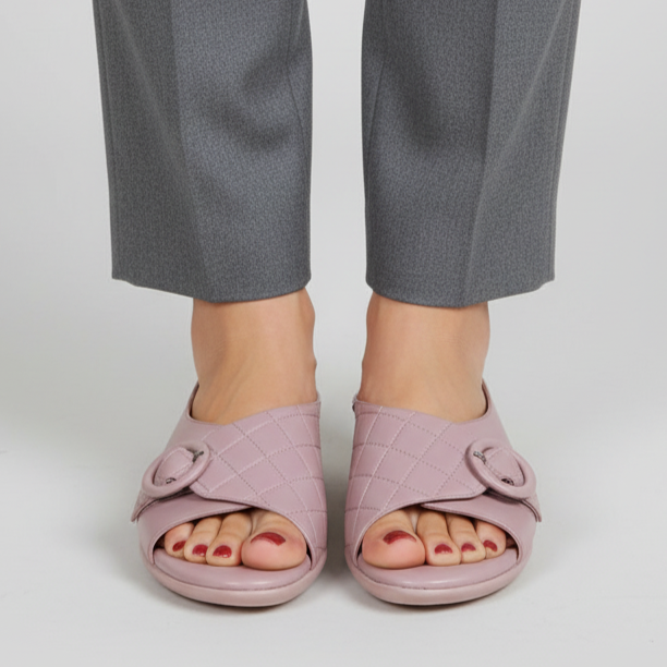 Person wearing pink sandals with a plain background