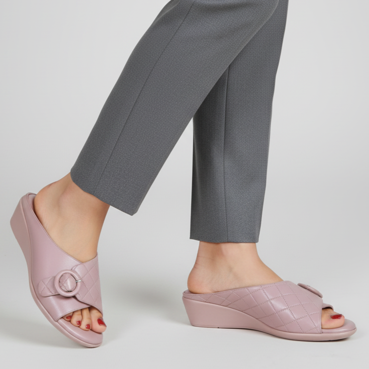 Person wearing pink sandals with gray pants on a light gray background