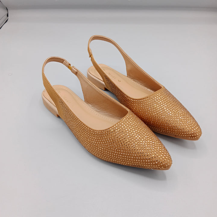 Pair of gold studded slingback shoes on a light gray background