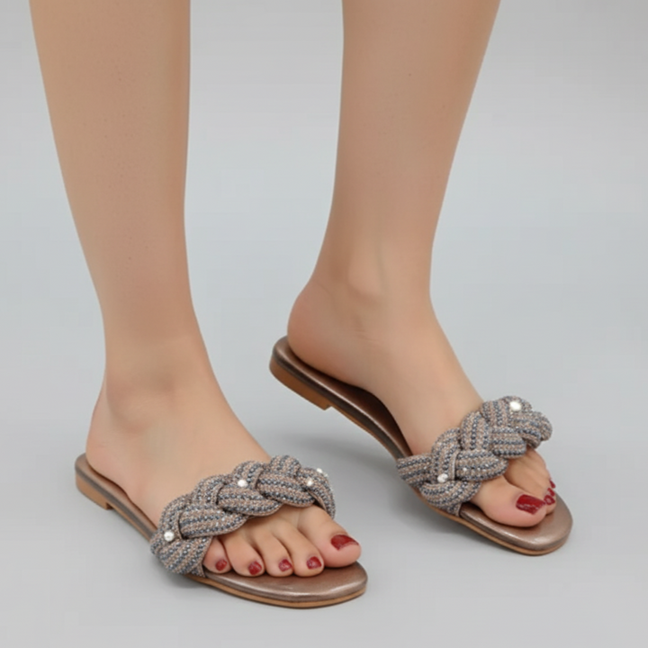 Braided sandal with embellishments on a neutral background
